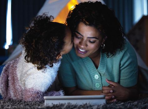 Nothing comes close to that real life connection. an adorable little girl using a digital tablet with her mother during bedtime at home.
