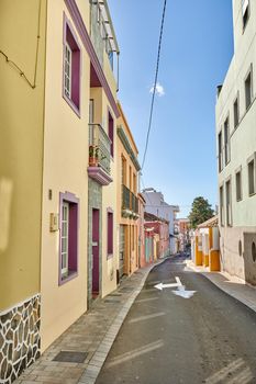 Historical city street view of residential houses in small and narrow alley or road in tropical Santa Cruz, La Palma, Spain. Village view of vibrant buildings in popular tourism destinations overseas