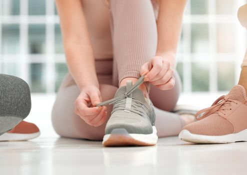 I kicked some butt today during my workout. an unrecognizable woman tying her shoelaces.