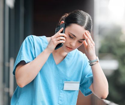 No more bad news please. a young female doctor on a call against a city background.