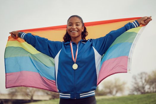 Everybody deserves to love. a female athlete holding a pride flag.