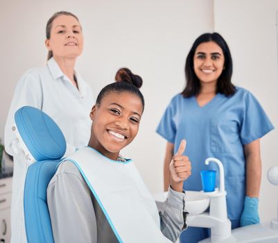 I have the best dentists. a young woman in her dentists office giving the thumbs up.