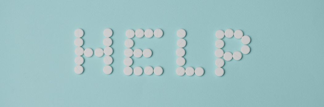 Help lettering made with white round shaped pill, drug prescription for treatment