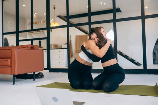 Two girlfriends hug each other after yoga