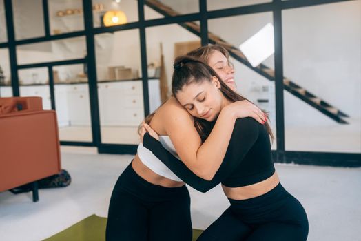 Two girlfriends hug each other after yoga