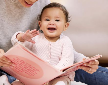 A babys laugh is like an angels voice. Shot a mother reading a book to her baby at home.
