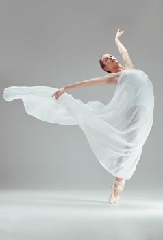 Elegance personified. Full length shot of an attractive young ballerina dancing alone in the studio.