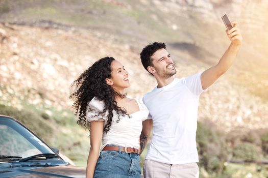 We take a selfie at every stop. a young couple taking a selfie while out on a road trip.