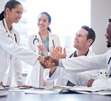 Youre going to do great things. a group of doctors applauding as a new team member is welcomed aboard during a meeting.
