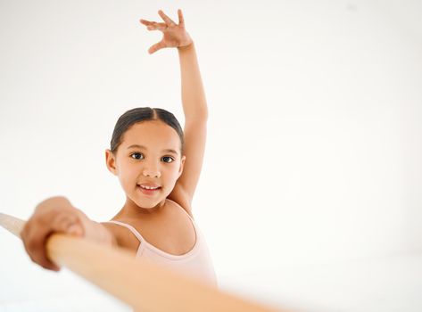 The cutest little ballerina. {Portrait of a little girl practicing ballet at a barre in a dance studio.