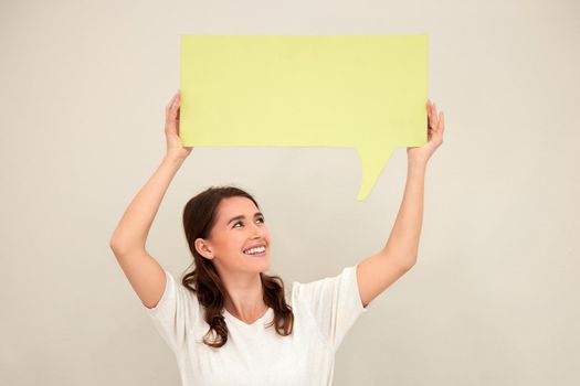 Speak whats on your mind. a young woman holding up a sign against a white background.