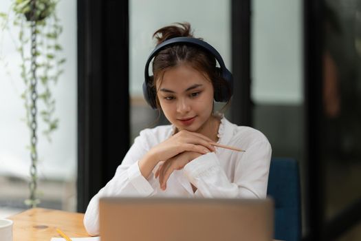 Woman focusing on webinars online class. Student wearing headphone to listening online class.