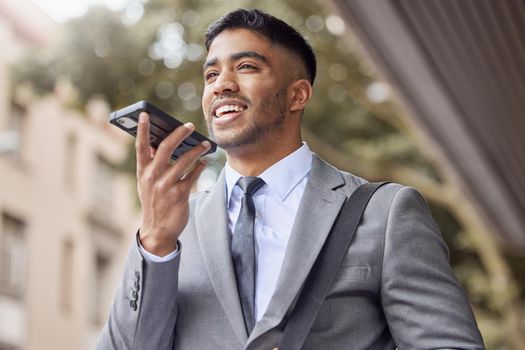 I prefer to send voice notes. a handsome young businessman walking through the city and using his cellphone.