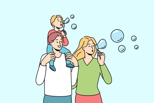 Happy family with kid blowing bubbles