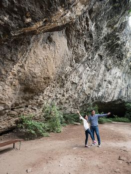 Couple having a good time away from the city exploring a cave in the mountains