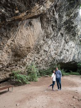 Beatiful young couple exploring a cave in the mountains