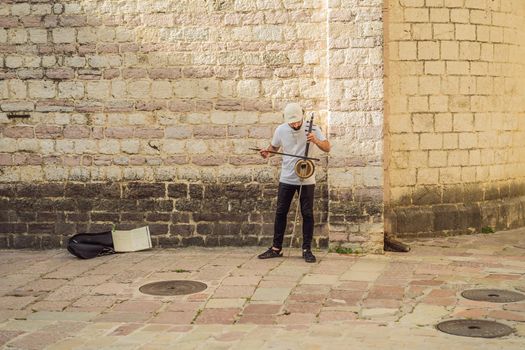 Montenegro Kotor May 27, 2022, the boy plays a musical instrument on the street, editorial