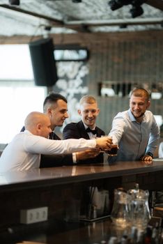 groom in a brown suit and his friends