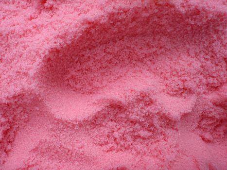 large amount of bright pink bath salt with scoop holes in it