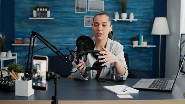 Popular tech enthusiast reviewing modern headphones while recording recommendation video