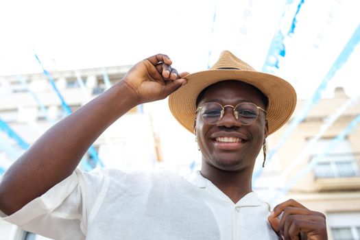 Happy black man wearing a hat smiling looking at camera during holidays abroad.