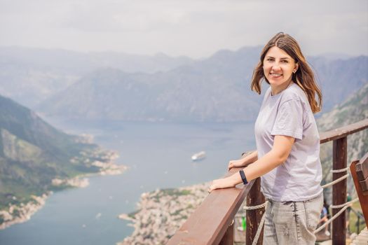Woman tourist enjoys the view of Kotor. Montenegro. Bay of Kotor, Gulf of Kotor, Boka Kotorska and walled old city. Travel to Montenegro concept. Fortifications of Kotor is on UNESCO World Heritage
