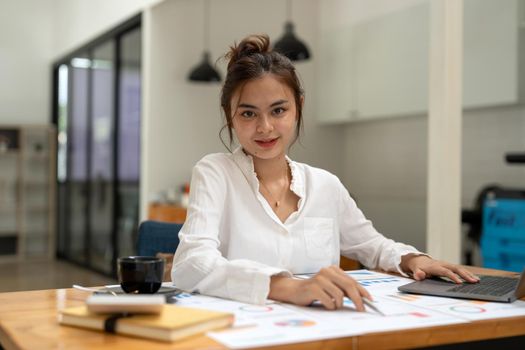Portrait of charming successful cheerful asian girl working remotely creating finance it presentation report at home house indoor