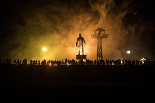 Creative artwork decoration - Russian war in Ukraine concept. Crowd looking on giant explosion and silhouette of giant person and watchtower. Selective focus