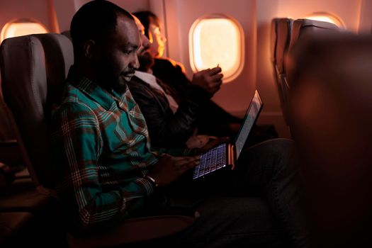 Modern traveller browsing internet on laptop and flying abroad