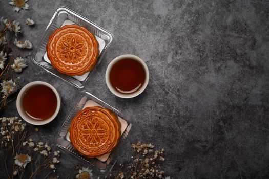 Above view moon cakes and tea on black stone background. Mid Autumn festival or Chinese traditional festival