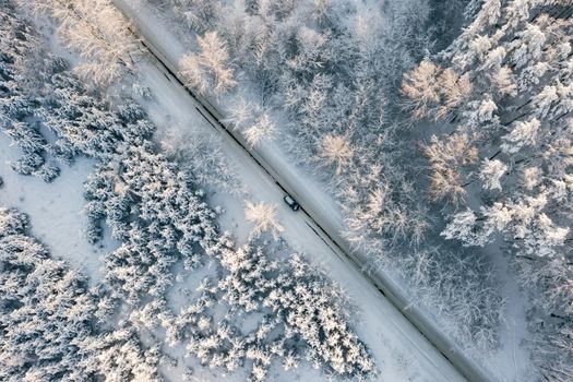 Car moving on winter asphalt road, aerial top view