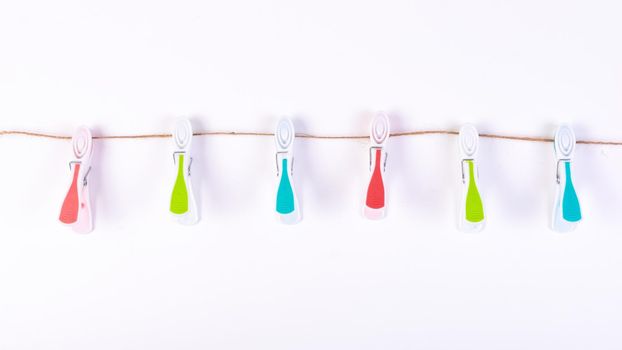 Color plastic clamp on a rope isolated on white background.