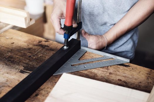 Woodworking operators are decorating pieces of wood to assemble and build wooden tables for customers.
