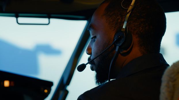 African american copilot preparing to takeoff and fly plane