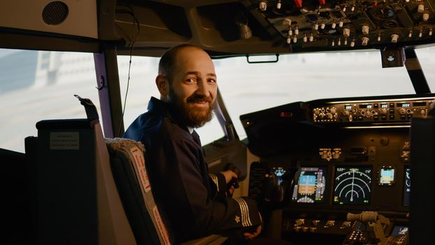 Portrait of airplane captain preparing to fly aircraft in cockpit