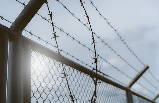 Prison security fence. Border fence. Barbed wire security fence. Razor wire jail fence. Boundary security wall. Prison for arrest of criminals or terrorists. Private area. Military zone concept. 