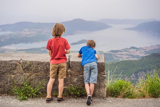 Two boys friend enjoys the view of Kotor. Montenegro. Bay of Kotor, Gulf of Kotor, Boka Kotorska and walled old city. Travel to Montenegro concept. Fortifications of Kotor is on UNESCO World Heritage