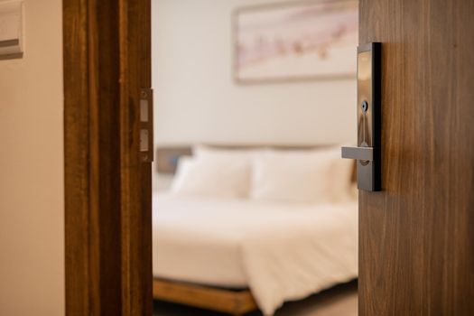 Condominium or apartment doorway with open door in front of blur bedroom background