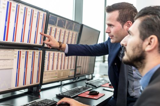 Stock traders looking at market data on computer screens.