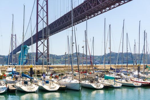 Berth with yachts under the Lisbon bridge April 25