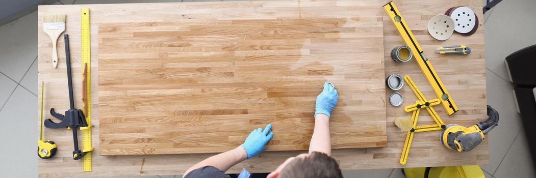 Carpenter handy man lacquer wooden plank at workroom