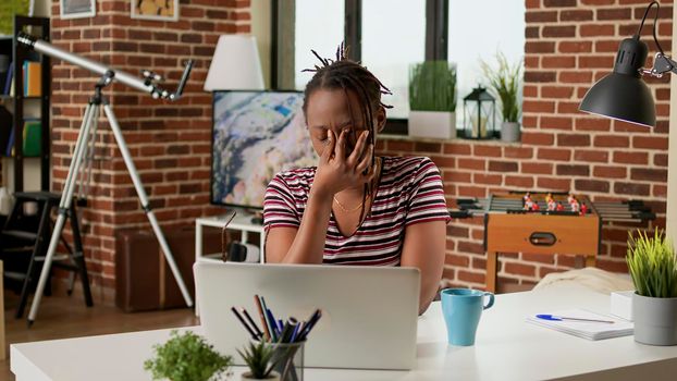 Stressed businesswoman with headache working remotely