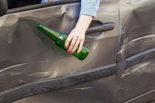 Drink and damaged car. woman holding drink bottle.