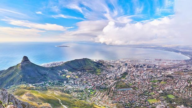 Copyspace landscape view of Lions Head and surroundings during the day in summer from above. Aerial view of the beautiful city of Cape Town with popular natural landmarks against a cloudy blu sky