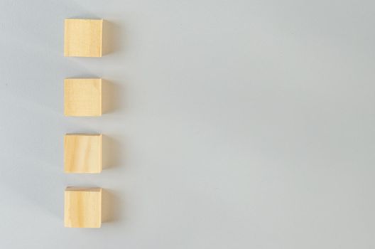 Blank wooden cubes for icons or symbols on gray background.