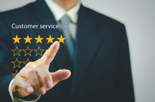 Businessman touching button to select five stars.Customer satisfaction and marketing survey rating concept