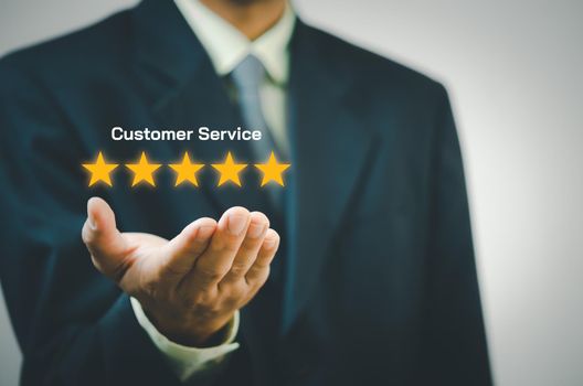 Businessman holding 5 stars on hands.Customer satisfaction and marketing survey rating concept