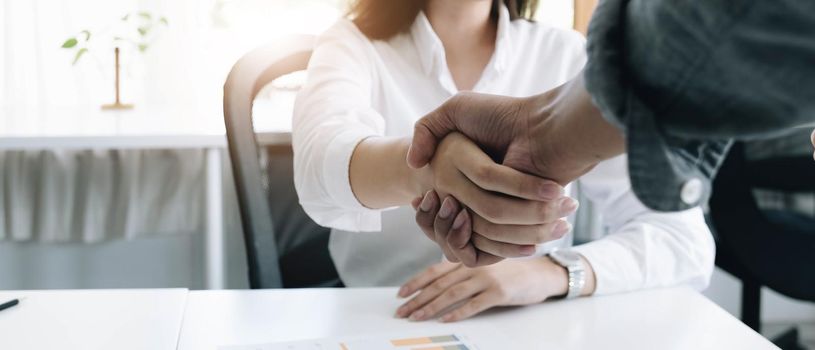 A close-up picture of a business shaking hands on a business cooperation agreement in the office. Concept of Cooperation business and success