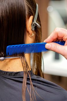 Hairdresser cuts hair of woman