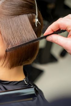 Hairdresser straightening short brown hair